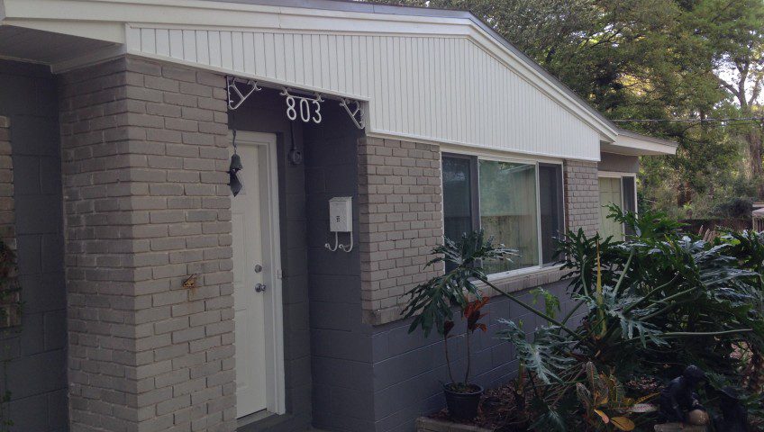 A house with a door open and a window closed.