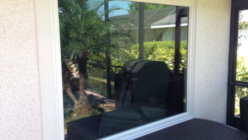 A window with a view of the trees and grass.