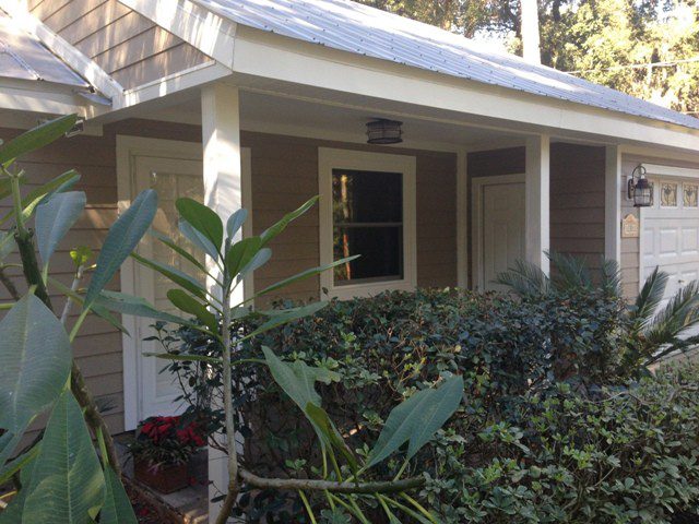 A house with plants and bushes in front of it.