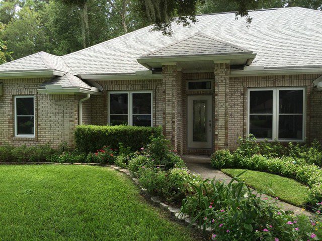 A house with a garden in the front yard.